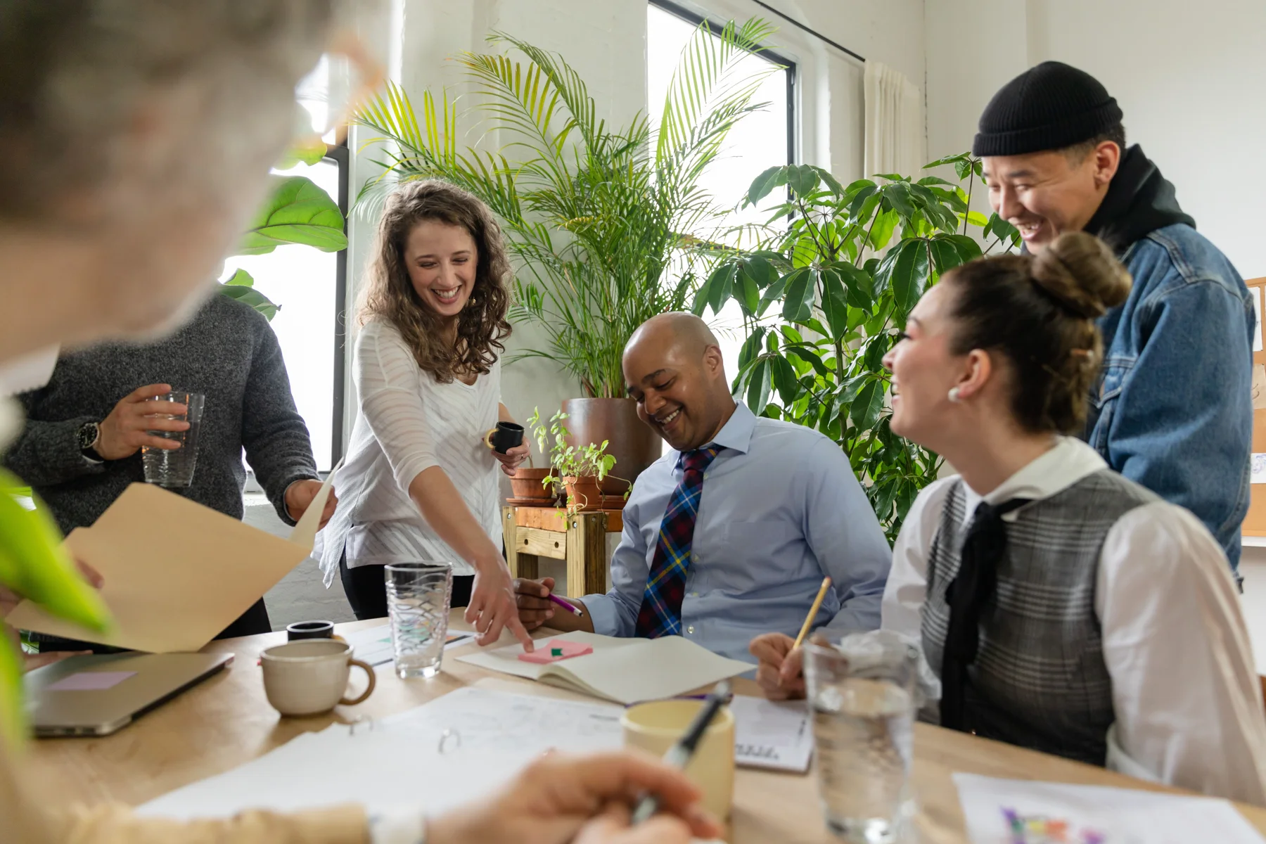 Colleagues sharing a relaxed moment around a meeting table.